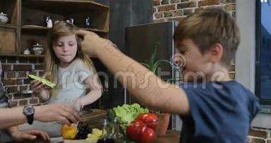 儿子拍摄的<strong>视频</strong>父母和姐姐在厨房用<strong>手机做</strong>饭，幸福的家庭一起在家准备